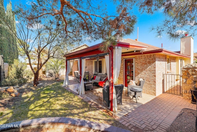 back of property with outdoor lounge area, a lawn, ceiling fan, and a patio area