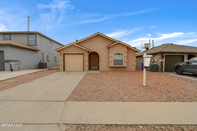 ranch-style house with an attached garage, central air condition unit, concrete driveway, and stucco siding