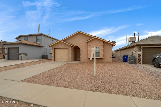 ranch-style house featuring cooling unit, concrete driveway, an attached garage, and stucco siding