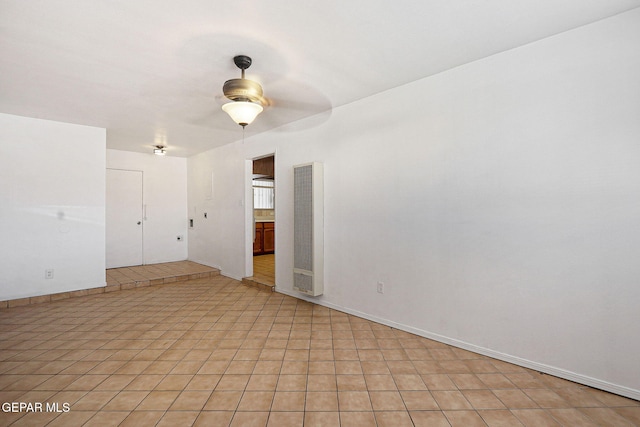 unfurnished room featuring a ceiling fan and baseboards