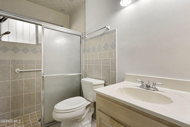 full bathroom with tiled shower, vanity, and toilet