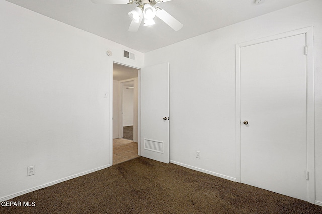 unfurnished bedroom with carpet, visible vents, and ceiling fan