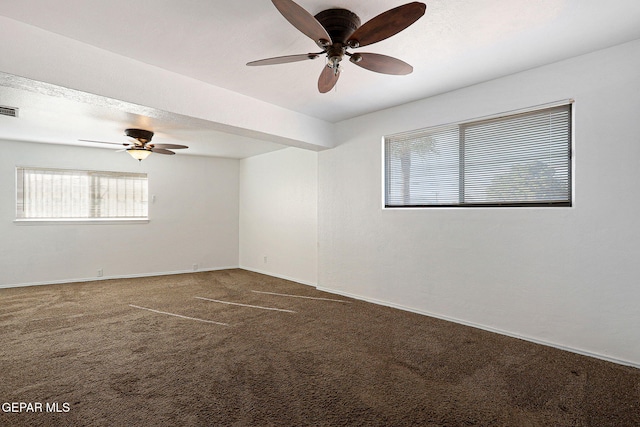 spare room with baseboards, visible vents, ceiling fan, dark colored carpet, and a textured ceiling