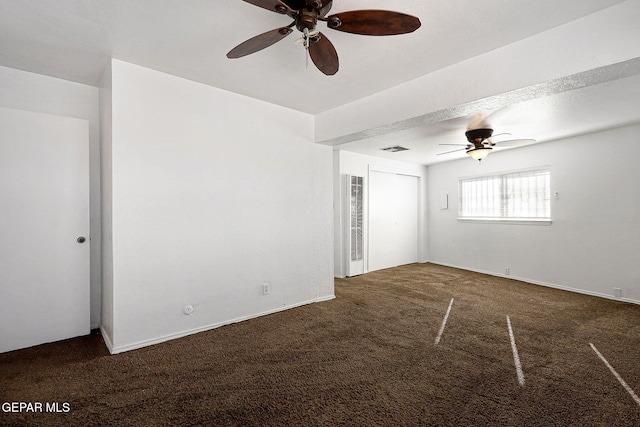 unfurnished bedroom with a ceiling fan, dark colored carpet, a closet, and visible vents