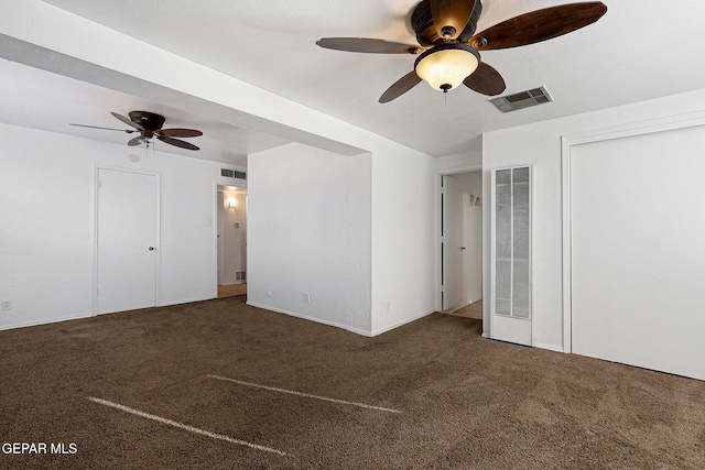 unfurnished bedroom with dark colored carpet, visible vents, and a ceiling fan