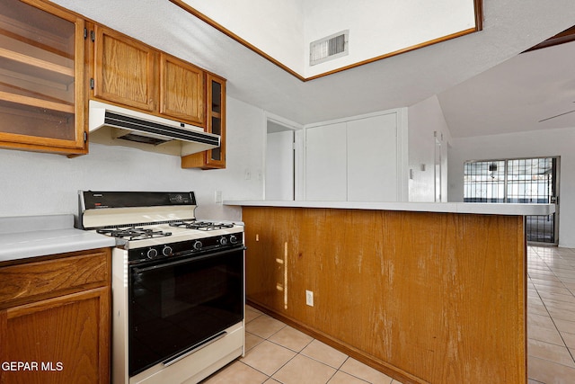 kitchen with visible vents, brown cabinetry, range with gas cooktop, light countertops, and under cabinet range hood