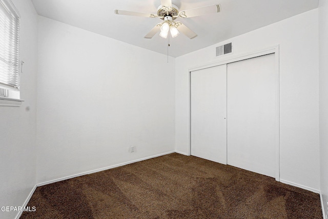 unfurnished bedroom featuring a closet, visible vents, carpet flooring, ceiling fan, and baseboards