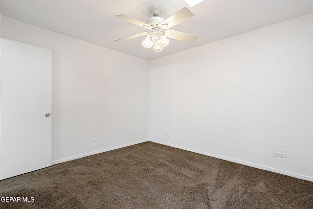 empty room with ceiling fan, dark carpet, and baseboards