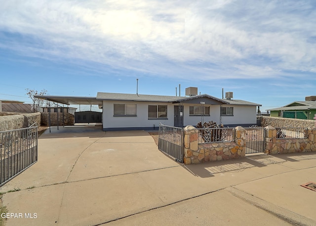 view of front of property featuring a fenced front yard, a gate, driveway, and stucco siding