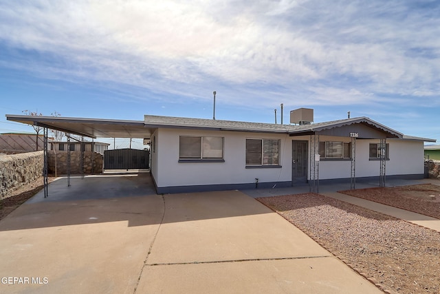 view of front of home with driveway, fence, and a carport