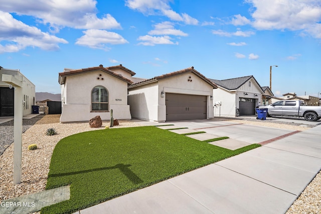 view of front of house featuring a tile roof, stucco siding, concrete driveway, an attached garage, and a front yard