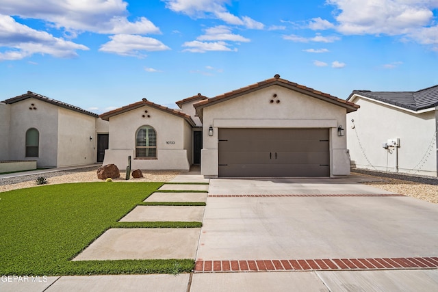 mediterranean / spanish-style house with driveway, a garage, a front lawn, and stucco siding