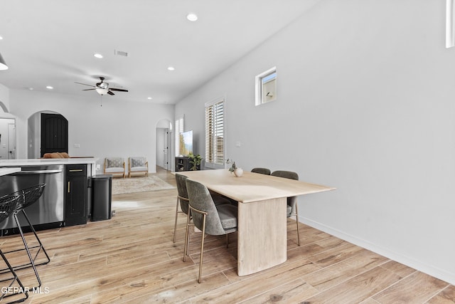 dining area featuring arched walkways, recessed lighting, visible vents, baseboards, and light wood-type flooring