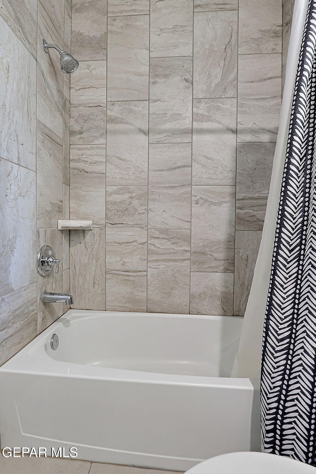 bathroom with shower / tub combo and toilet