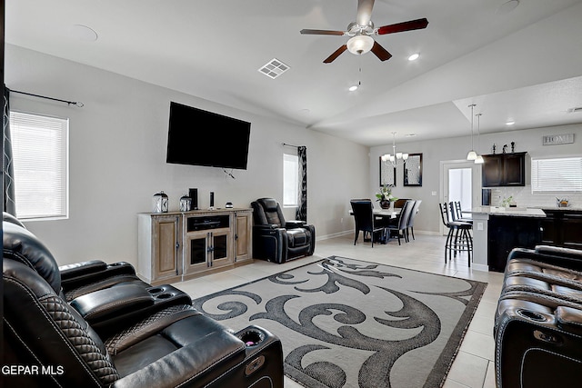 tiled living room with lofted ceiling and ceiling fan with notable chandelier