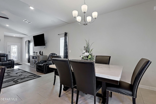 dining area featuring lofted ceiling, light tile patterned floors, and an inviting chandelier