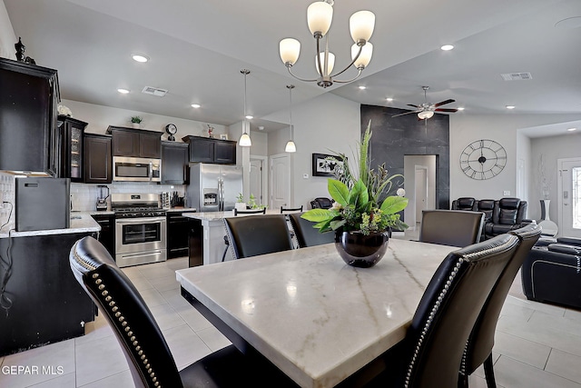 tiled dining room with ceiling fan with notable chandelier