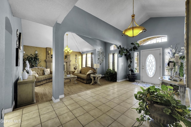 foyer entrance with lofted ceiling and light tile patterned flooring