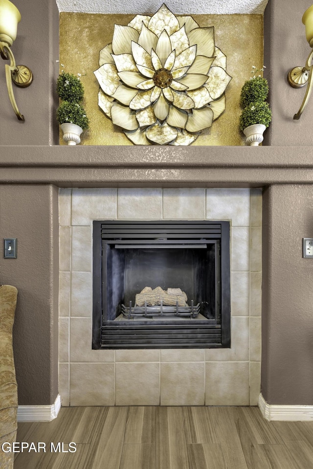 interior details featuring a fireplace and wood-type flooring