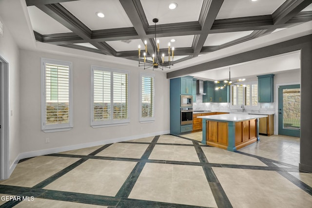 kitchen with pendant lighting, appliances with stainless steel finishes, a center island, and a notable chandelier