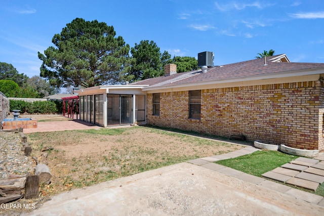 11204 Bob Mitchell Dr, El Paso, TX 79936 - rear view of property featuring central AC unit, a patio, a sunroom, and brick siding
