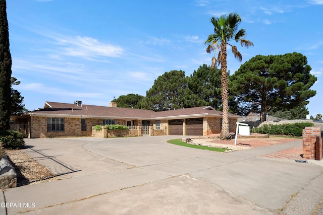 11204 Bob Mitchell Dr, El Paso, TX 79936 - ranch-style house with concrete driveway, brick siding, and a garage