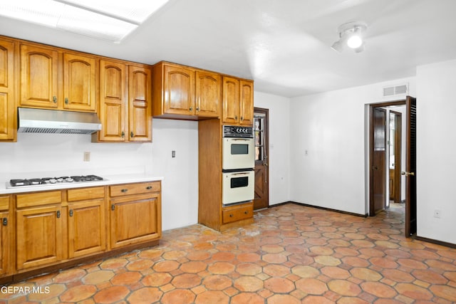 11204 Bob Mitchell Dr, El Paso, TX 79936 - kitchen with white appliances, brown cabinets, visible vents, under cabinet range hood, and light countertops