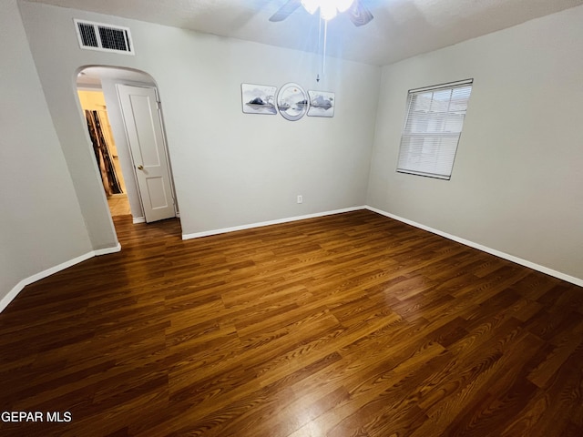 spare room with dark wood-type flooring and ceiling fan