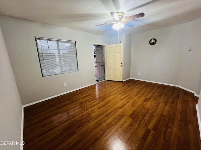 empty room with ceiling fan, wood-type flooring, and a textured ceiling