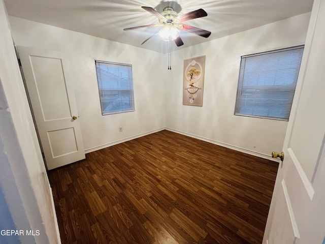 empty room featuring dark wood-type flooring and ceiling fan