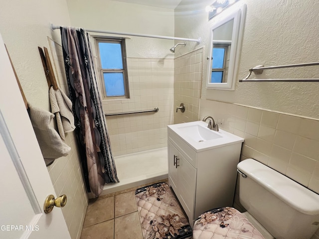 bathroom with tile walls, vanity, tile patterned floors, toilet, and walk in shower