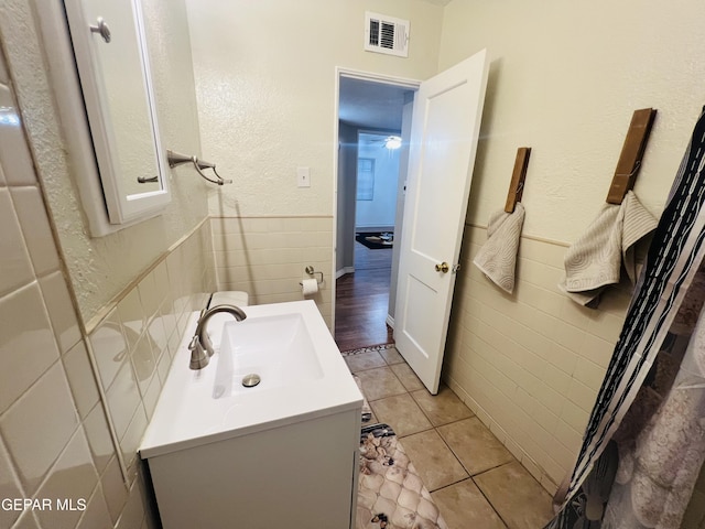 bathroom featuring tile patterned floors, vanity, and tile walls