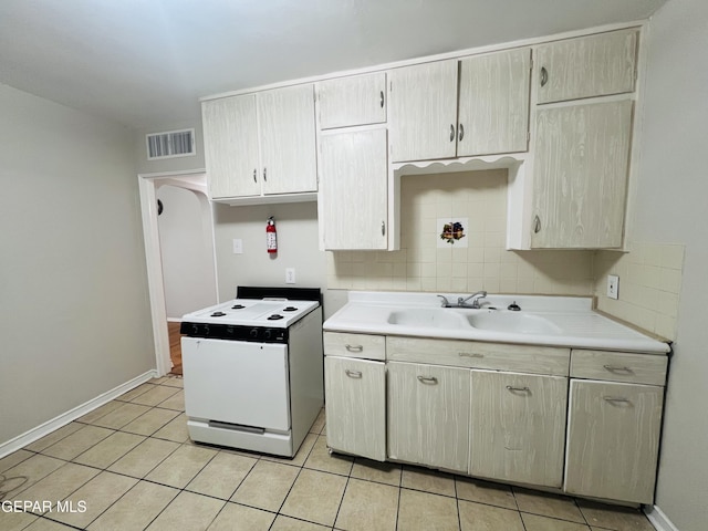 kitchen with sink, decorative backsplash, and light tile patterned floors