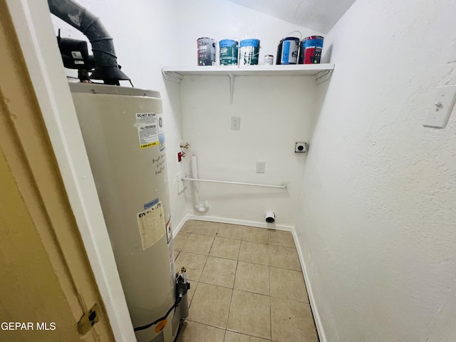 clothes washing area featuring light tile patterned floors, water heater, and electric dryer hookup