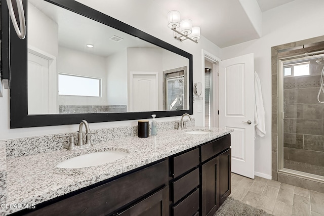 bathroom with vanity, plenty of natural light, and a shower with shower door