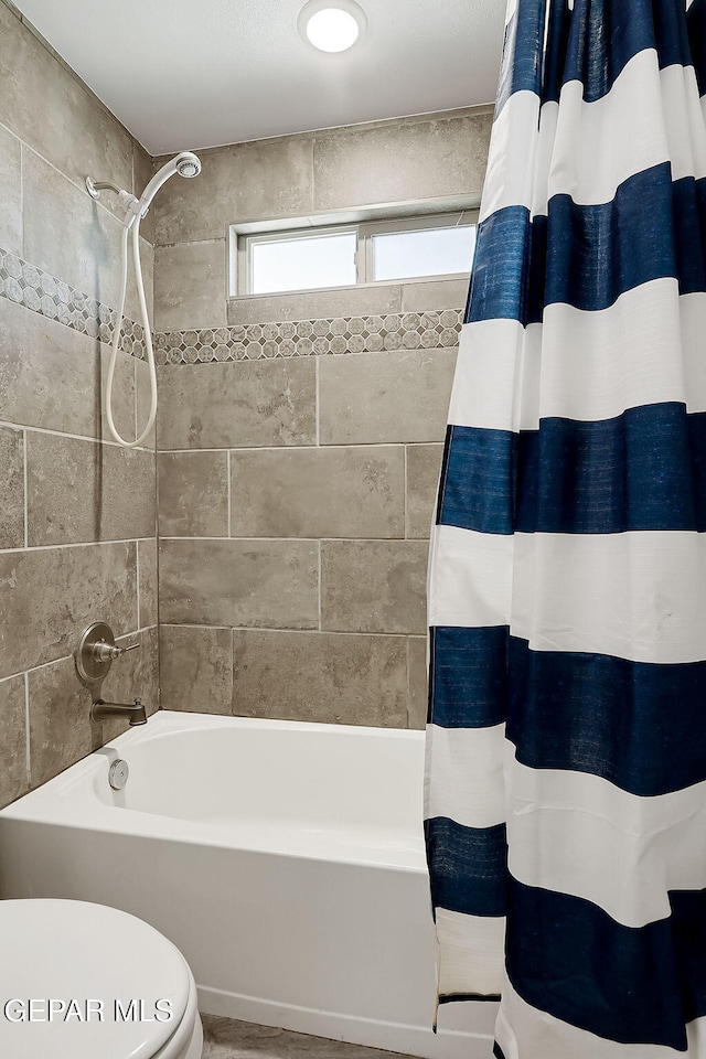 bathroom with shower / bath combo and toilet