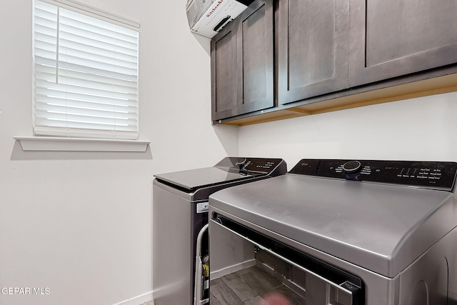 laundry room with cabinets, wood-type flooring, and washer and clothes dryer