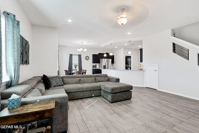 living room with hardwood / wood-style flooring and a notable chandelier