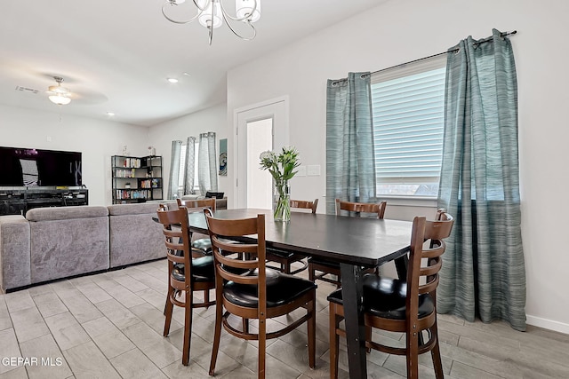 dining area featuring ceiling fan with notable chandelier