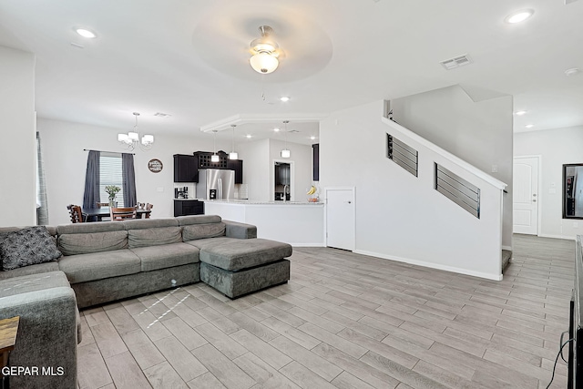 living room featuring a notable chandelier and light wood-type flooring