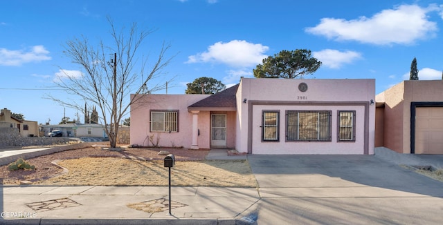 pueblo revival-style home featuring a garage