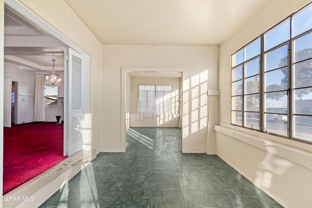 hallway with an inviting chandelier and a wealth of natural light