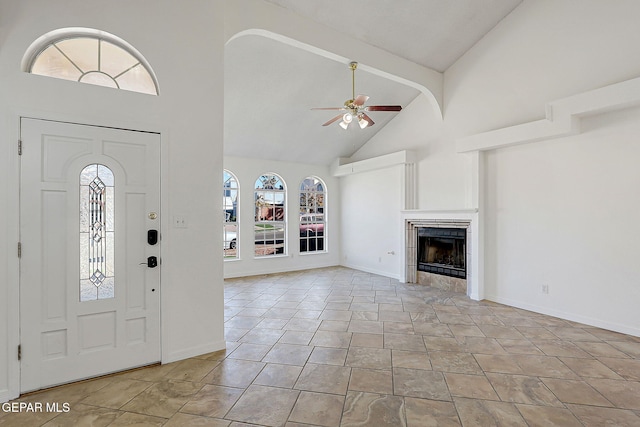 foyer featuring a tiled fireplace, beamed ceiling, high vaulted ceiling, and ceiling fan