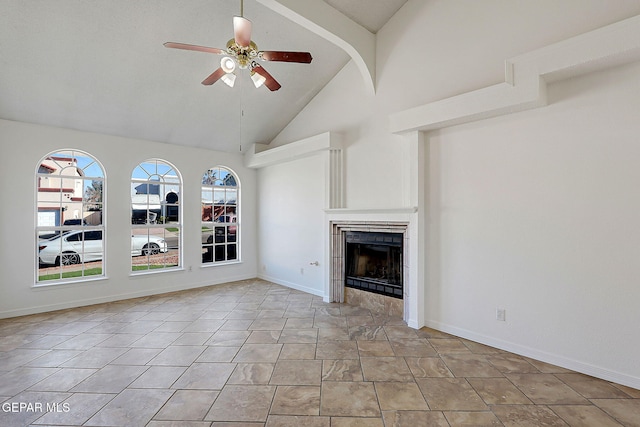 unfurnished living room featuring ceiling fan, a tiled fireplace, and high vaulted ceiling