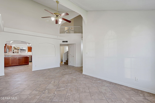 unfurnished living room featuring beamed ceiling, high vaulted ceiling, and ceiling fan