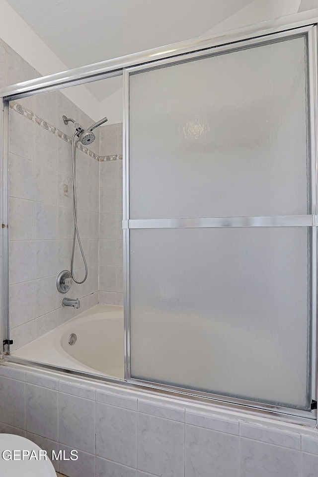 bathroom with enclosed tub / shower combo and toilet