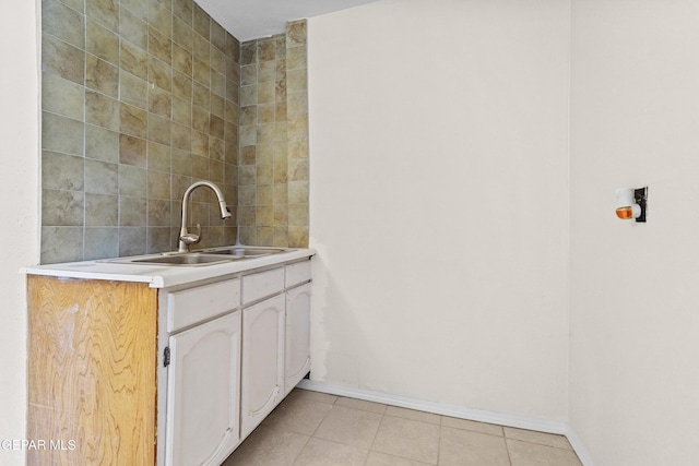 interior space featuring white cabinetry, light tile patterned flooring, and sink