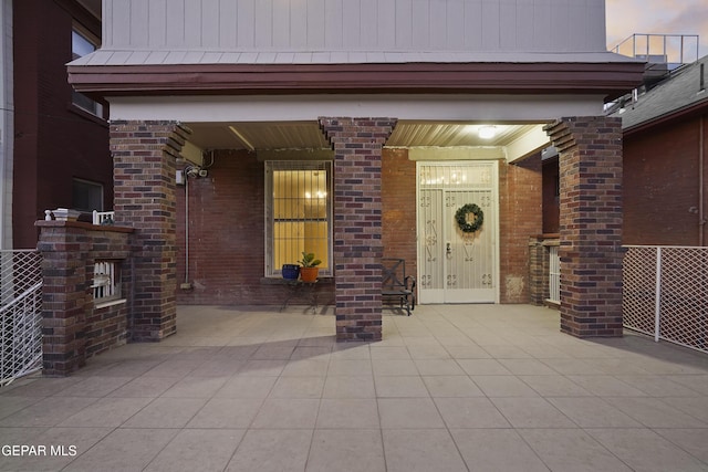 exterior entry at dusk featuring a patio