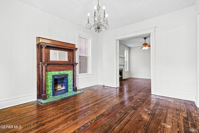 unfurnished living room with dark hardwood / wood-style floors and ceiling fan with notable chandelier