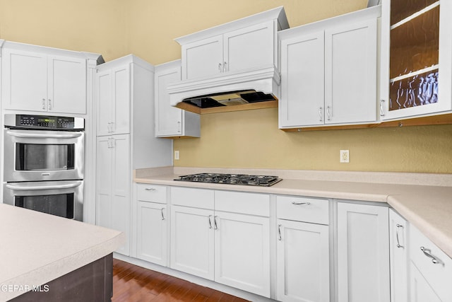 kitchen featuring white cabinetry, stainless steel appliances, dark hardwood / wood-style floors, and premium range hood